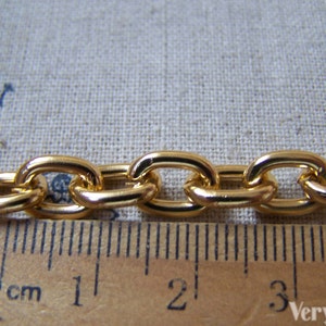 May include: Gold chain link with oval links, measuring 4 cm in length.