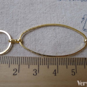 May include: Gold chain with oval and round links. The chain is measured against a ruler, showing it is approximately 5 inches long.