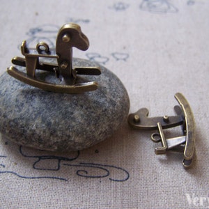 Puede incluir: Encanto de caballo de balanc&iacute;n de metal dorado antiguo. El encanto mide aproximadamente 2,5 cm de largo y presenta un dise&ntilde;o detallado de caballo de balanc&iacute;n. El encanto es perfecto para agregar un toque de fantas&iacute;a a las joyas o las manualidades.