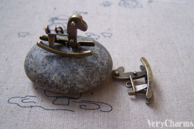 Puede incluir: Encanto de caballo de balanc&iacute;n de metal dorado antiguo. El encanto mide aproximadamente 2,5 cm de largo y presenta un dise&ntilde;o detallado de caballo de balanc&iacute;n. El encanto es perfecto para agregar un toque de fantas&iacute;a a las joyas o las manualidades.