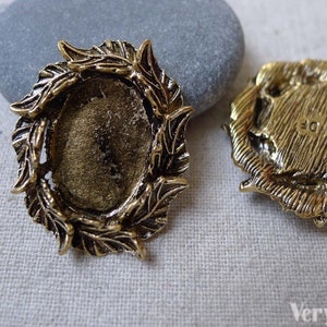 Puede incluir: Marco de metal dorado con diseño de hojas, perfecto para añadir un toque de elegancia a tus proyectos de elaboración de joyas. El marco está diseñado para contener un cabujón redondo de 25 mm.
