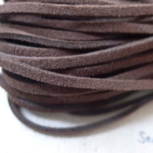 Può includere: Primo piano di un rotolo di cordoncino in pelle scamosciata marrone. Il cordoncino è morbido e flessibile, ed è perfetto per progetti di artigianato.