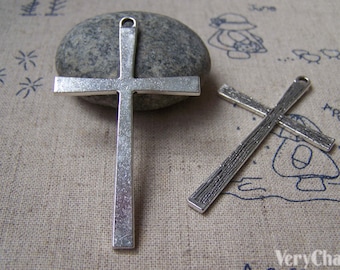 May include: Two silver-toned metal cross charms. One cross is plain and the other has a textured surface.