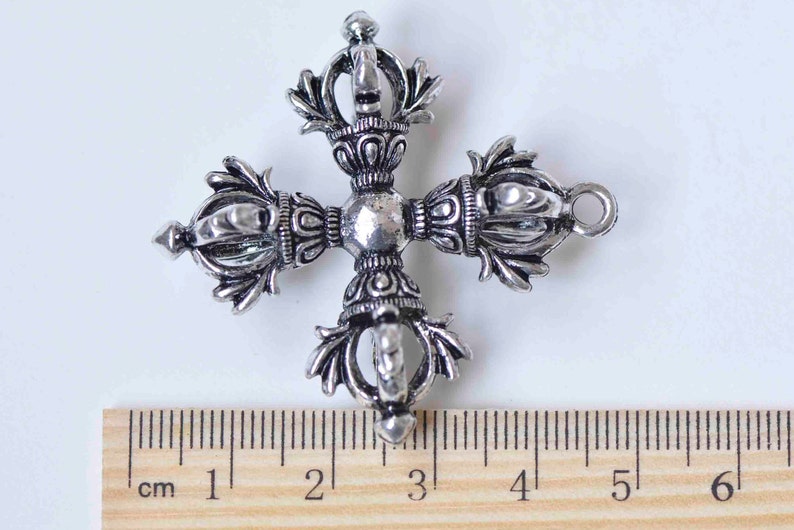 May include: Silver-toned metal pendant in the shape of a four-pointed star with intricate details. The pendant measures approximately 3 cm in diameter.