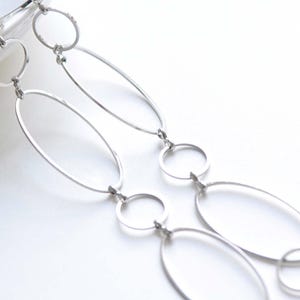 May include: A silver chain necklace with oval and round links. The chain is made of metal and has a polished finish.