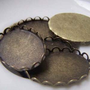 May include: Three oval-shaped metal settings with scalloped edges. The settings are made of brass and have a vintage, antique look.