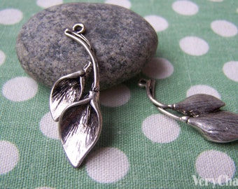 May include: Two silver metal leaf charms with a textured finish. The charms have a loop at the top for attaching to jewelry or other crafts.
