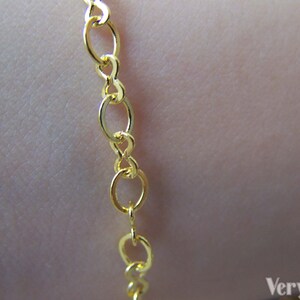 May include: A gold chain necklace with a delicate, oval-shaped link design.