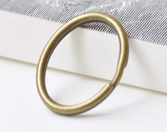 May include: A gold-toned metal key ring with a circular shape.