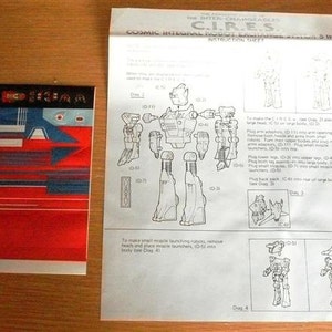 May include: A black and white instruction sheet for a C.I.R.E.S. Cosmic Integral Robot, showing the steps to assemble the robot. The sheet includes diagrams of the robot in different stages of assembly.