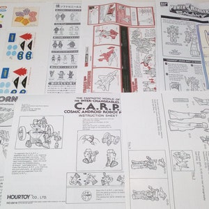 Könnte beinhalten: Eine Anleitung zum Bau eines Roboter-Spielzeugs. Die Anleitung ist auf weißem Papier gedruckt und enthält Diagramme und Text. Der Text enthält die Wörter "C.A.R.P. Cosmic Android Robot" und "C.I.R.E.S. Inter-Changeables Cosmic Integral Robot Exchange System 5 in 1".