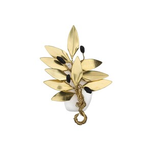 May include: A gold-toned metal leaf and berry brooch. The brooch features multiple gold leaves and small black berries, arranged around a white stone base. The stem and base are wrapped in gold wire.