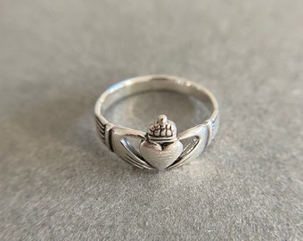 May include: A silver Celtic knot ring with a heart design. The ring is a traditional Irish symbol of love and eternity.
