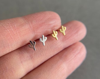 May include: Four pairs of small cactus-shaped earrings in silver, gold, and rose gold.