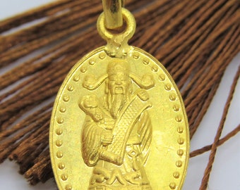 May include: A gold-colored pendant featuring a detailed image of a Chinese deity, possibly the God of Wealth, with a scroll in his hand. The pendant is oval-shaped and has a beaded border.