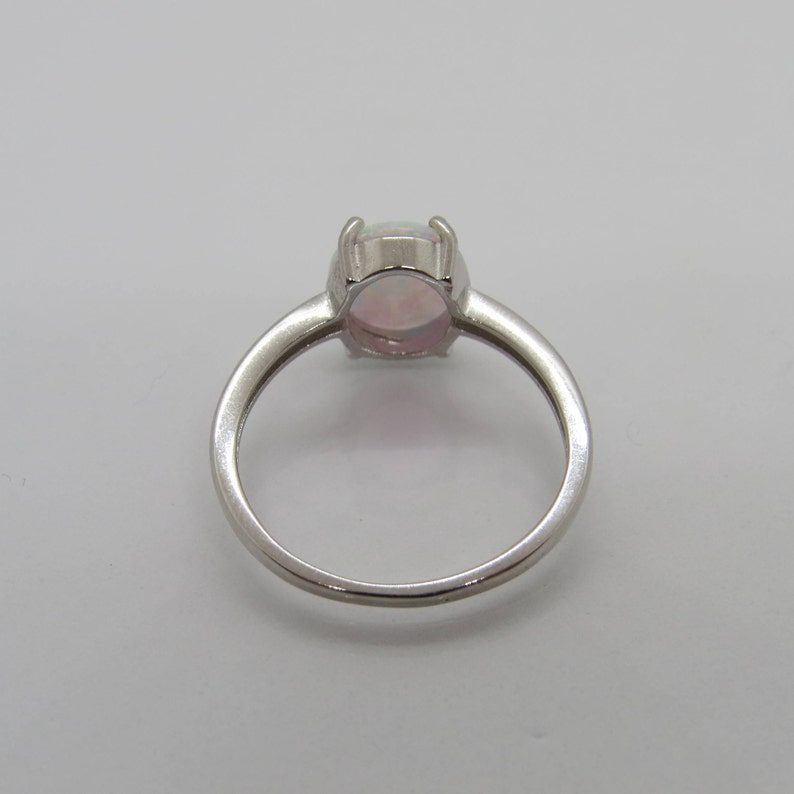 Peut inclure: Une bague en argent avec une opale blanche. La bague est de style simple et &eacute;l&eacute;gant.