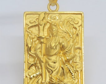 May include: A gold pendant featuring a detailed relief of a Chinese deity holding a staff, surrounded by intricate designs. The pendant is rectangular and has a loop at the top for attaching to a chain.