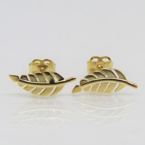 May include: A pair of gold leaf stud earrings. The earrings are made of a delicate, detailed design.