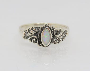 Könnte beinhalten: Ein silberner Ring mit einem weißen Opal-Edelstein, der in einem floralen Design gefasst ist.