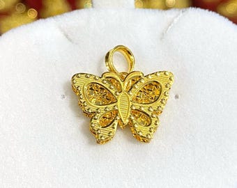 May include: A gold butterfly pendant charm with intricate details. The pendant has a loop at the top for attaching to a chain or bracelet.