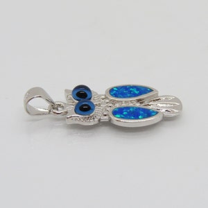 May include: Silver owl pendant with blue opal wings and blue evil eye details.