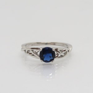 May include: A silver ring with a blue gemstone set in a Celtic knot design.