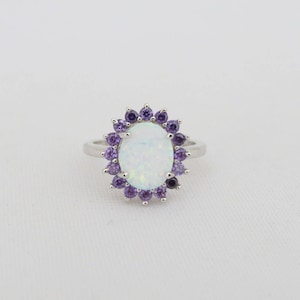 May include: A silver ring with a white opal center stone surrounded by a halo of purple amethyst stones.