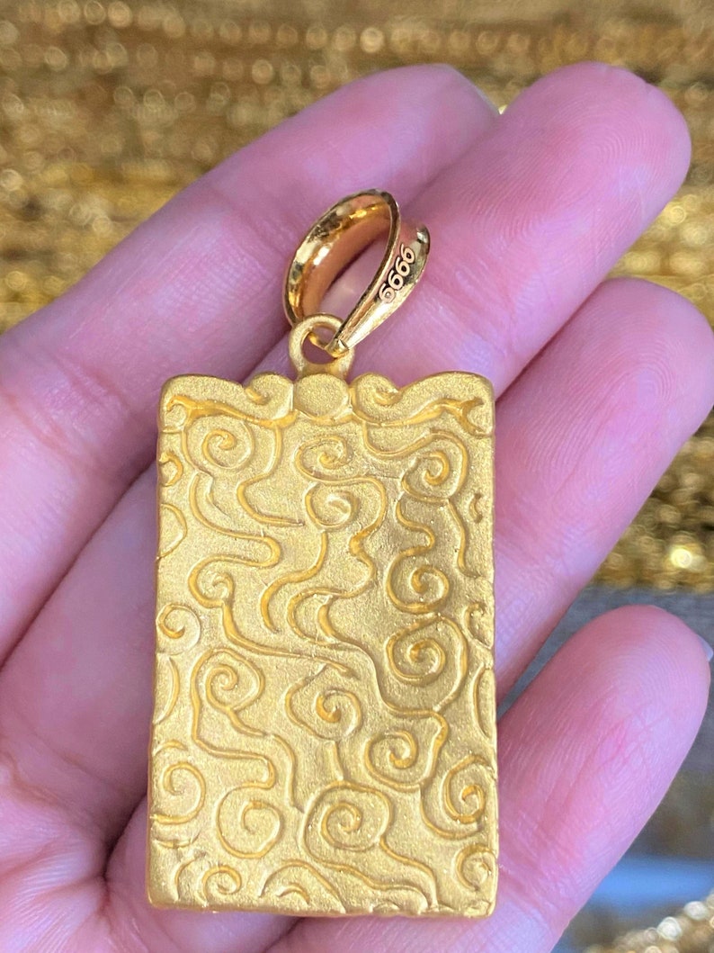 Pu&ograve; includere: Ciondolo in oro di forma quadrata con un motivo a spirale. Il ciondolo ha un anello in alto ed &egrave; contrassegnato dal numero "9999".