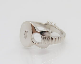 May include: A silver ring shaped like a guitar. The ring is detailed with a fretboard and tuning pegs.