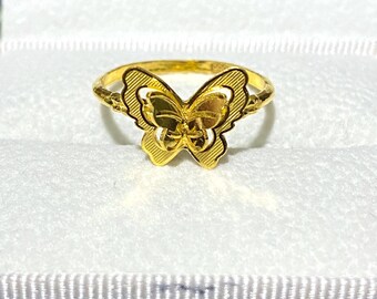 May include: A gold butterfly ring with a detailed design. The ring is in a white box with a blue lining.