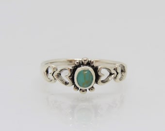 May include: A silver ring with a turquoise stone set in a heart-shaped design.