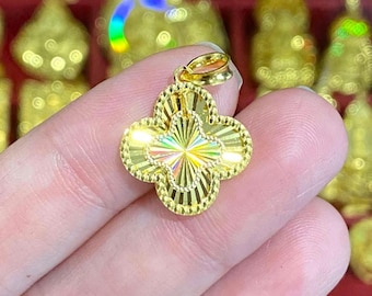 May include: A gold pendant in the shape of a four-leaf clover with a textured surface.