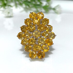 May include: A silver ring with a cluster of yellow gemstones set in a flower-like design.
