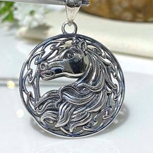 May include: Silver pendant featuring a detailed Celtic knot design with a horse's head in the center.