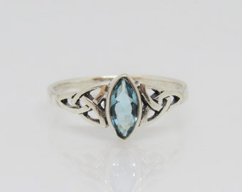 May include: A silver ring with a Celtic knot design and a light blue marquise-shaped gemstone.