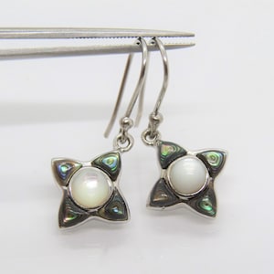May include: Silver dangle earrings with a white mother of pearl center surrounded by iridescent abalone shell accents.