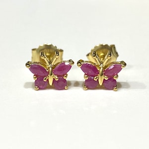May include: A pair of gold butterfly earrings with pink ruby stones.