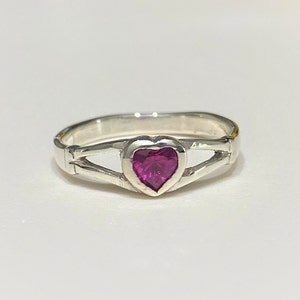 May include: A silver ring with a heart-shaped pink gemstone.