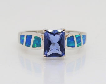 Può includere: Un anello d'argento con una pietra preziosa blu e dettagli in opale blu e verde.