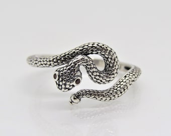 May include: A silver snake ring with red gemstone eyes. The snake is coiled around the ring band.