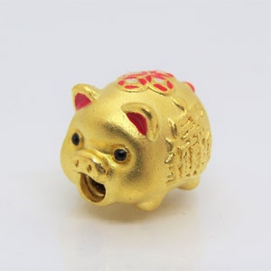 May include: A gold piggy bank with red accents and Chinese characters. The piggy bank has a slot on the side for coins.