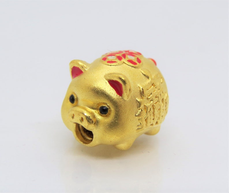 May include: A gold piggy bank with red accents and Chinese characters. The piggy bank has a slot on the side for coins.