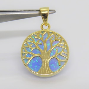 May include: A gold-tone pendant featuring a tree of life design with a blue opal inlay.