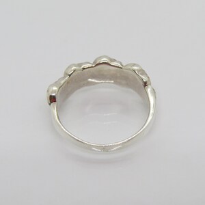May include: A silver ring with a textured, organic design. The ring is smooth and polished.