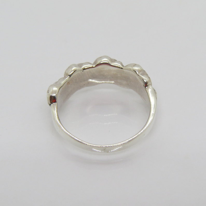 May include: A silver ring with a textured, organic design. The ring is smooth and polished.