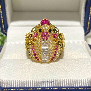 Peut inclure: Une bague en or avec un motif de bijoux rose et blanc en forme d'insecte stylisé. La bague est présentée dans une boîte blanche.