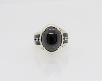 May include: A silver ring with a black oval gemstone set in a decorative silver setting.