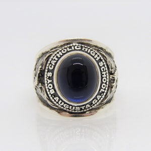 May include: Silver class ring with a blue stone and the inscription "Boys' Catholic High School Augusta GA".