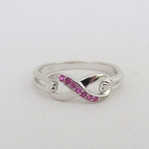 May include: A silver infinity ring with a row of pink gemstones.
