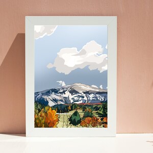 Peut inclure: Une illustration encadr&eacute;e d'un paysage de montagne avec un sommet enneig&eacute;, un ciel bleu avec des nuages blancs et une vall&eacute;e avec des arbres verts et orange.